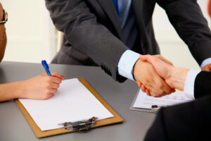 men shaking hands after signing papers