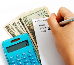 money, calculator, list of monthly expenses